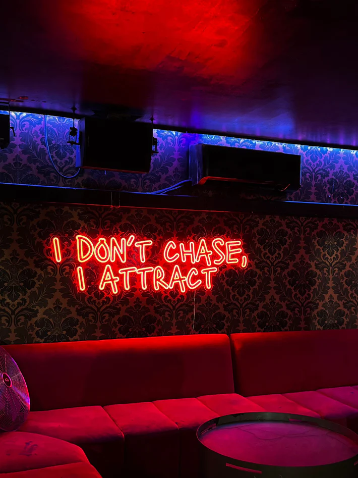Néon LED rouge avec la citation I don't chase, I attract